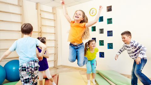 Kinder turnen und springen auf Matten 