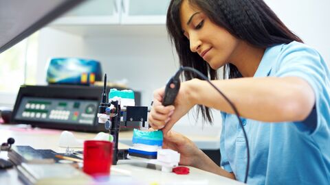 Technischer Beruf Ein Technikerin bearbeitet ein Modell mit einer Fräse