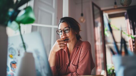 Frauenförderung und Gleichstellung Eine Frau, die zuhause konzentriert im Homeoffice arbeitet
