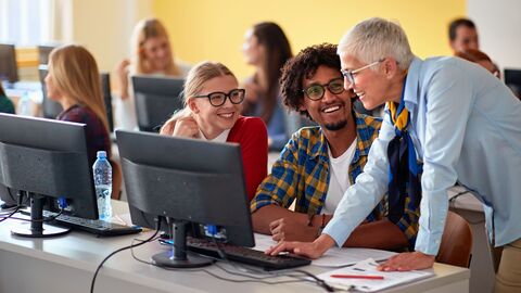 Eine Lehrerin, mit einer Klasse älterer Schüler im Medienraum