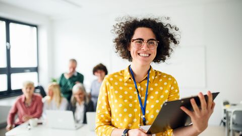 Eine Lehrerin in einem Workshop mit einer Mappe in der Hand