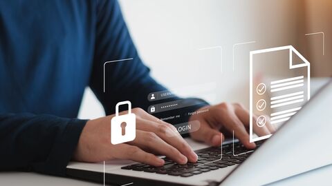 Datenschutzbeauftragter Ein Mann, der auf einem Notebook tippt; man sieht Symbole für Datensicherheit
