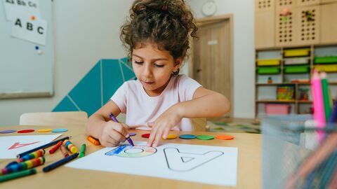 Ein Mädchen, das gerade übt, den Buchstaben A zu schreiben 
