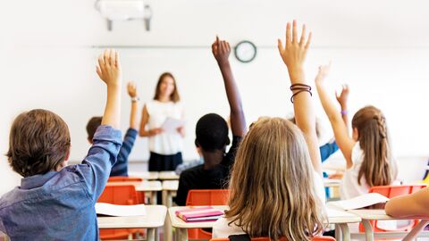 Schulangebot Blick in ein Klassenzimmer während des Unterrichts; die Kinder melden sich gerade