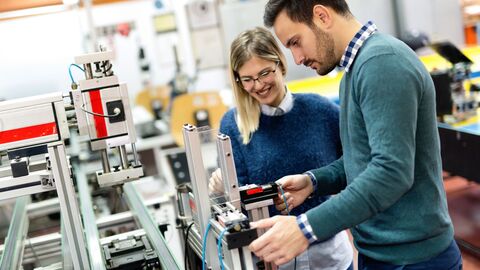 Fachlehrerausbildung Eine Lehrerin und ein Lehrer an einer technischen Produktionsstraße