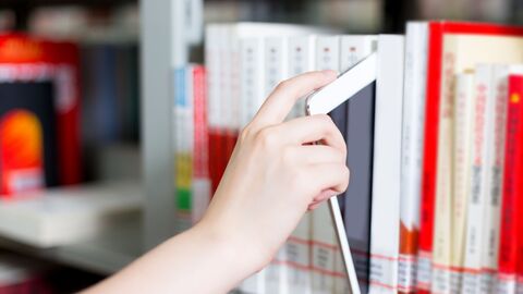Barrierefreiheit Eine Hand zieht ein Tablett aus einem Bücherregal