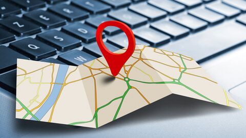 Pinnadel mit Karte vor Notebook