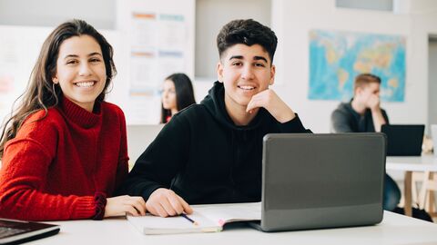 Zwei Jugendliche in einem Klassenraum